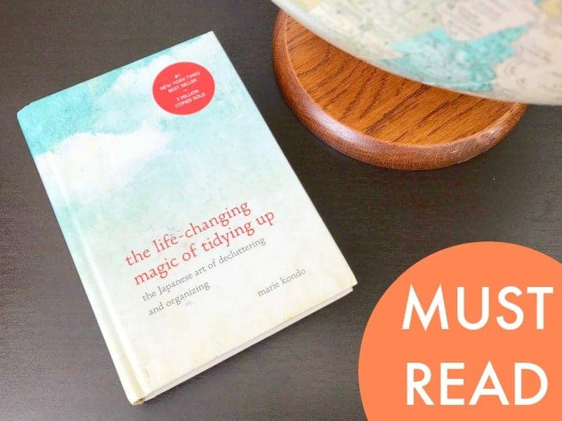 KonMari method book laying next to a globe