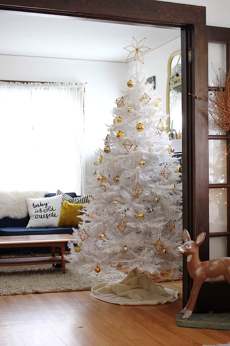 A white minimalist christmas tree with gold ornaments