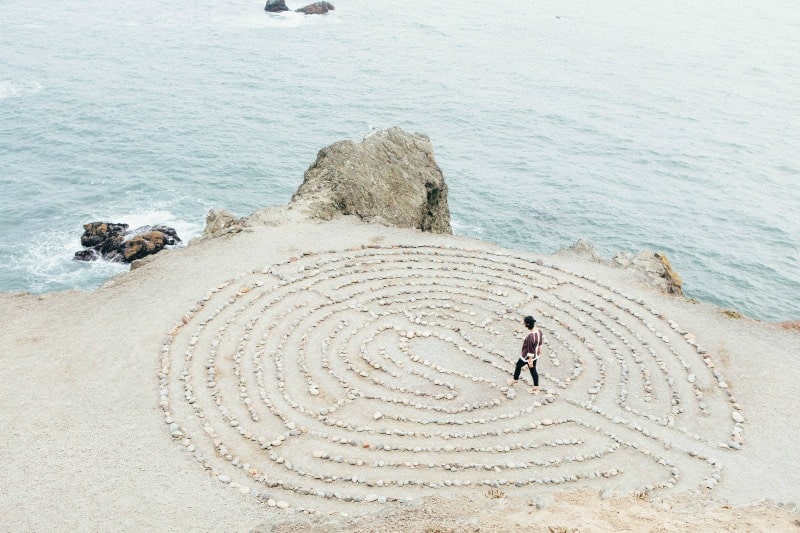 A minimalist walking in a stone circle by the ocean
