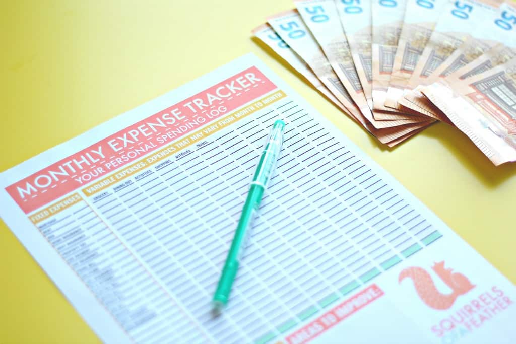 Close up of a free printable monthly expense tracker on a yellow table