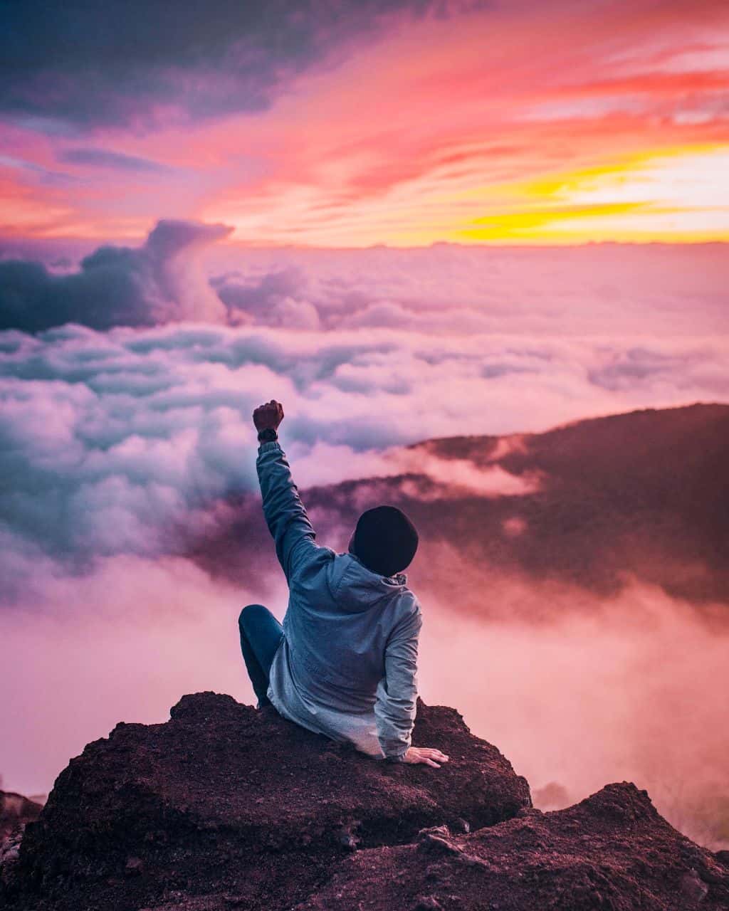 A man raising his fist to the sunrise because he is debt free