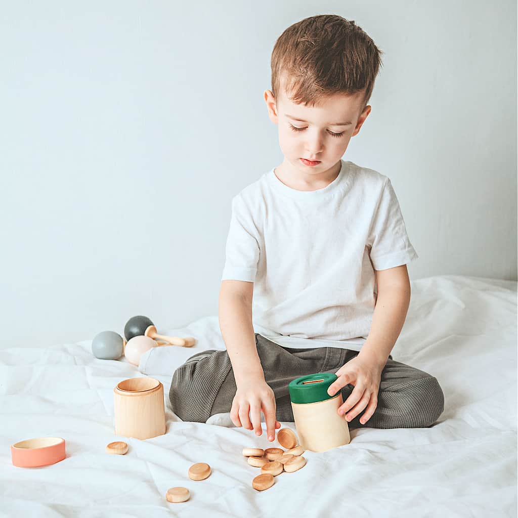 A boy playing with simple toys made from wood