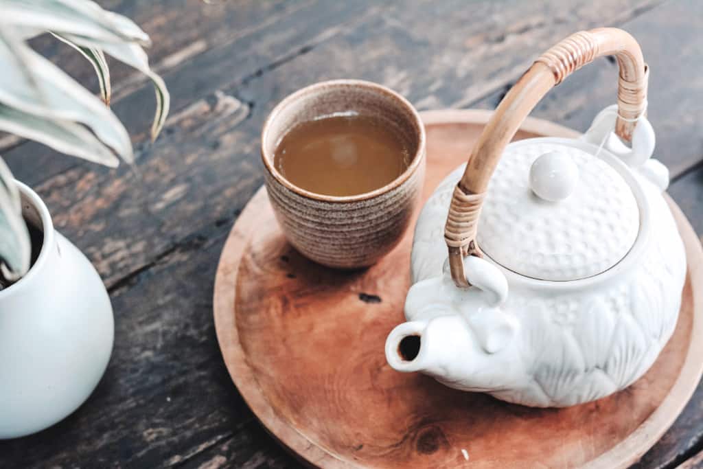 A minimalist living room table with tea and a plant