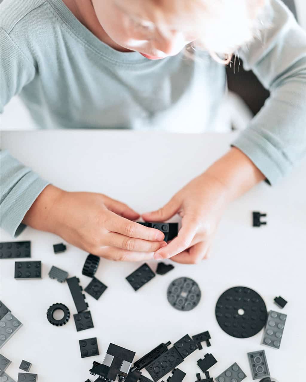 A boy playing with his favorite minimalist toys, LEGOs