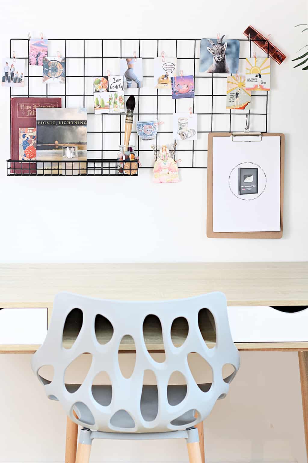 A minimalist office wall grid dream board with blue chair