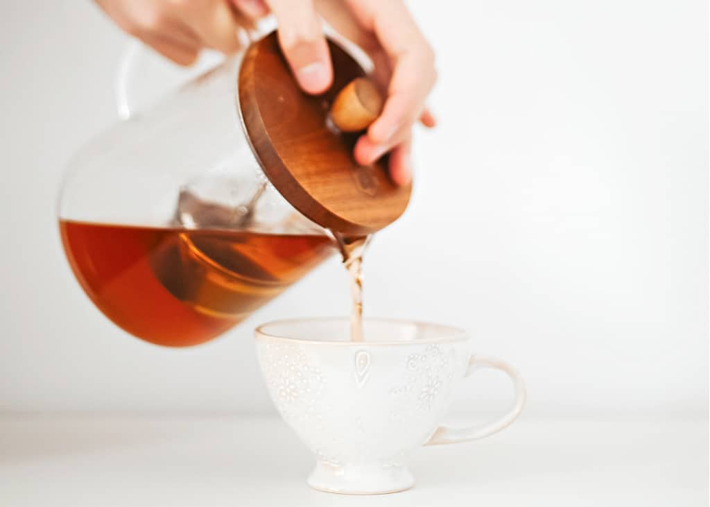 A woman pouring tea as part of intentional living practice