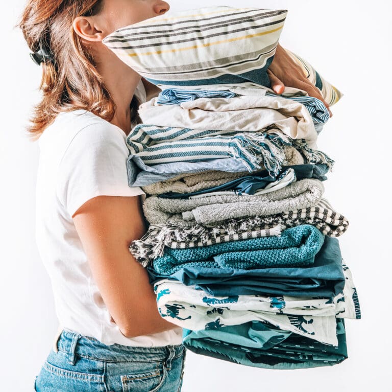 A woman carrying clothes she decluttered in her home