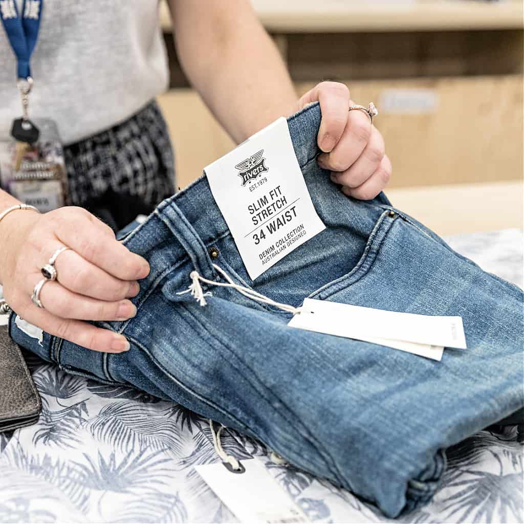 A woman impulse buying expensive jeans at a store