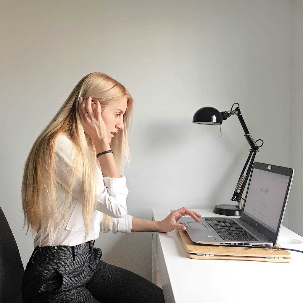 A woman feeling overwhelmed and looking up how to stop the stress online