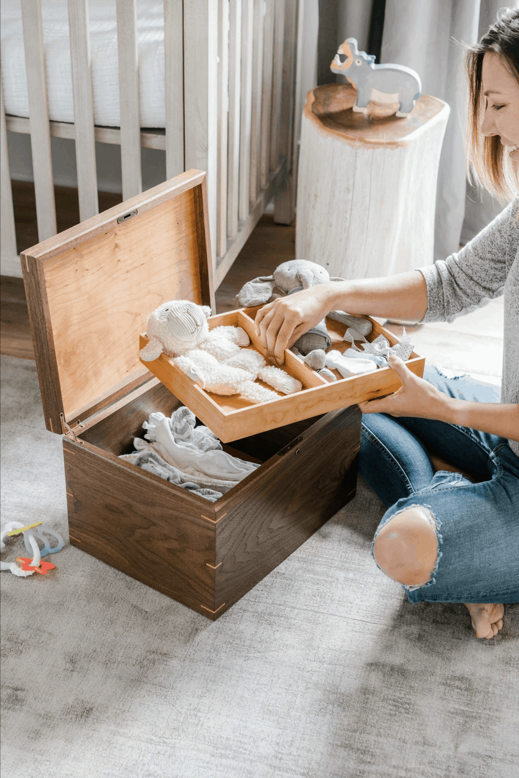 A woman making a memory box for her child using a wooden box