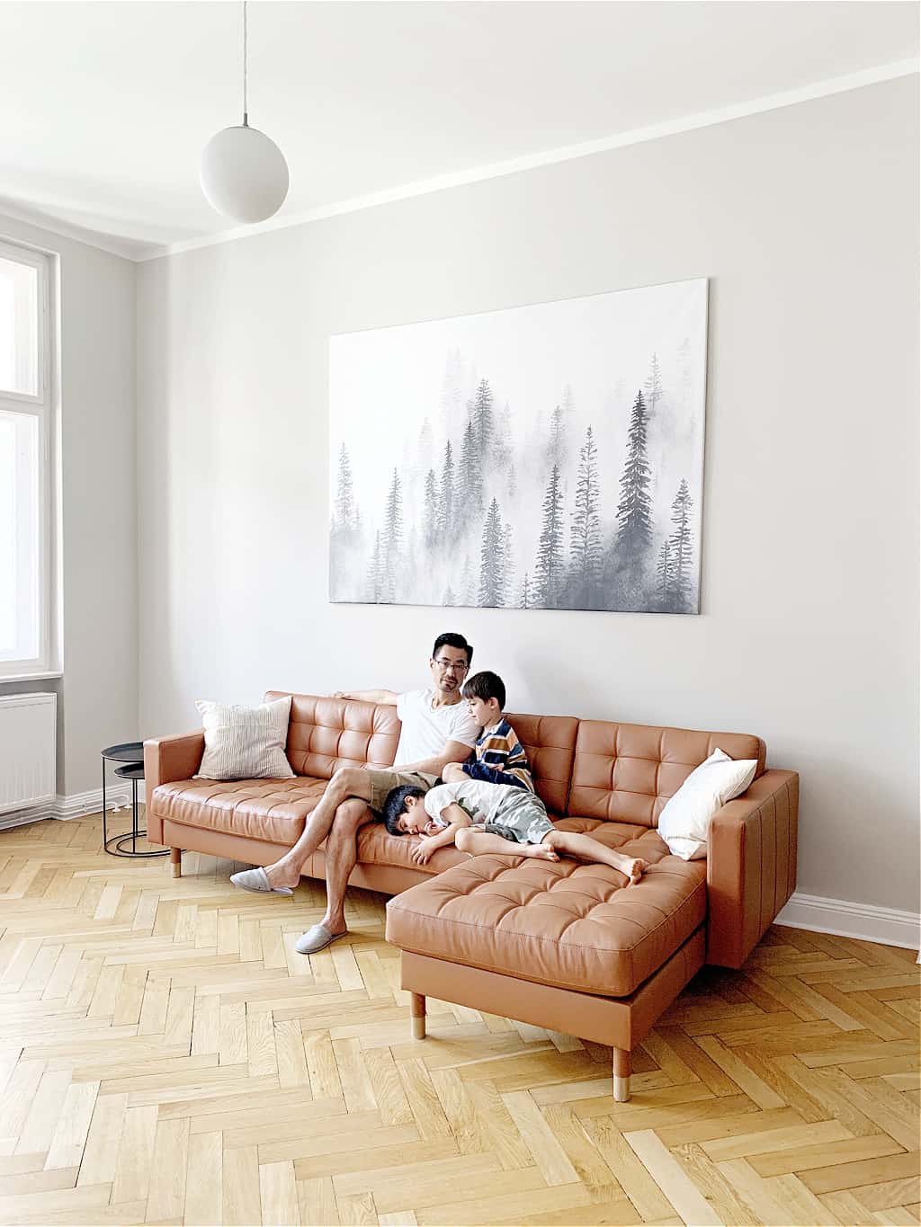 A minimalist family sitting on a couch in their minimalist living room.
