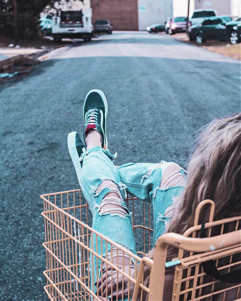 A woman in a shopping cart regretting not shopping like a minimlalist
