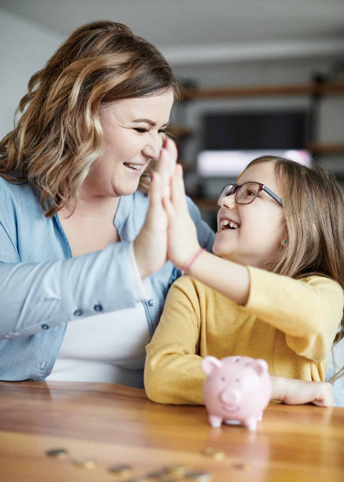 A mom high-fiving her daughter after a successful 52-week money challenge.