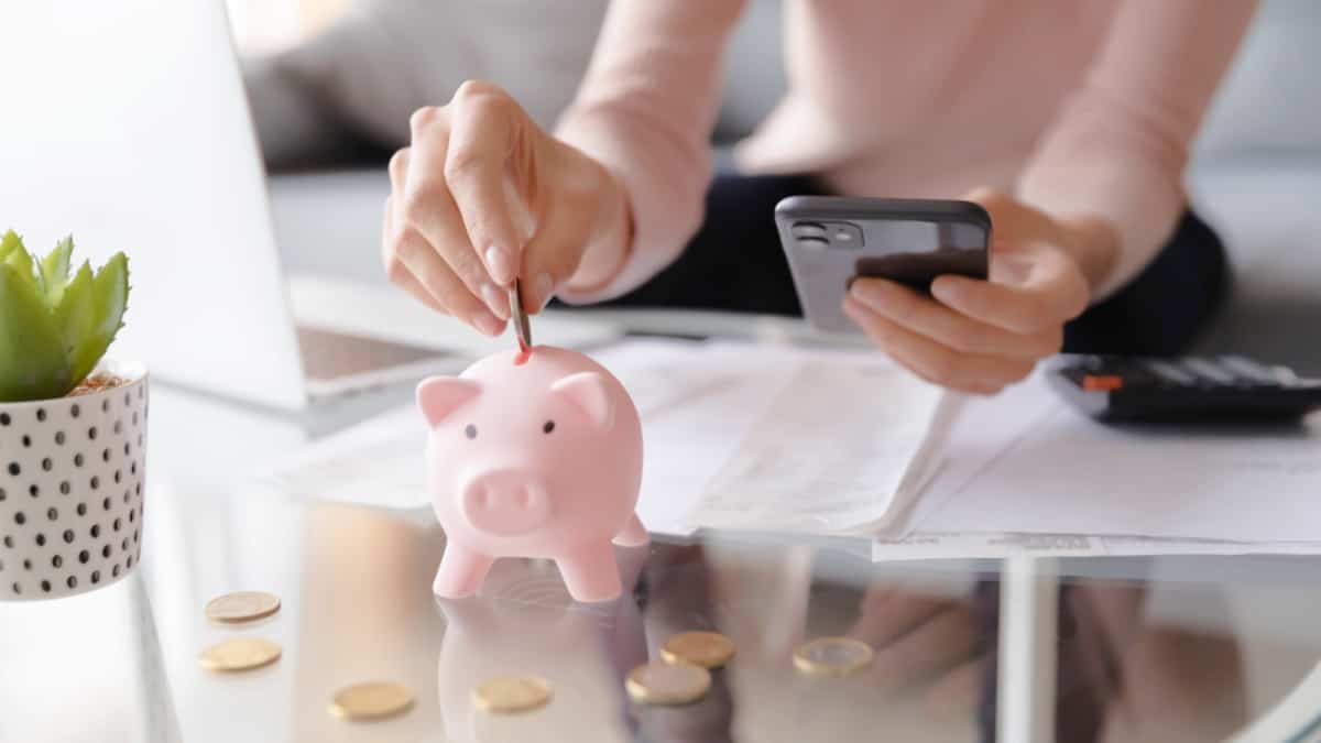 A woman using the 52-week money challenge to save money and put it in a piggy bank