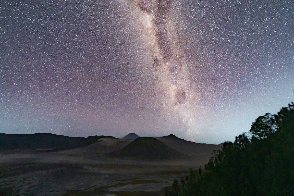 A man thinking about ambition gazing at the milk way in the dark