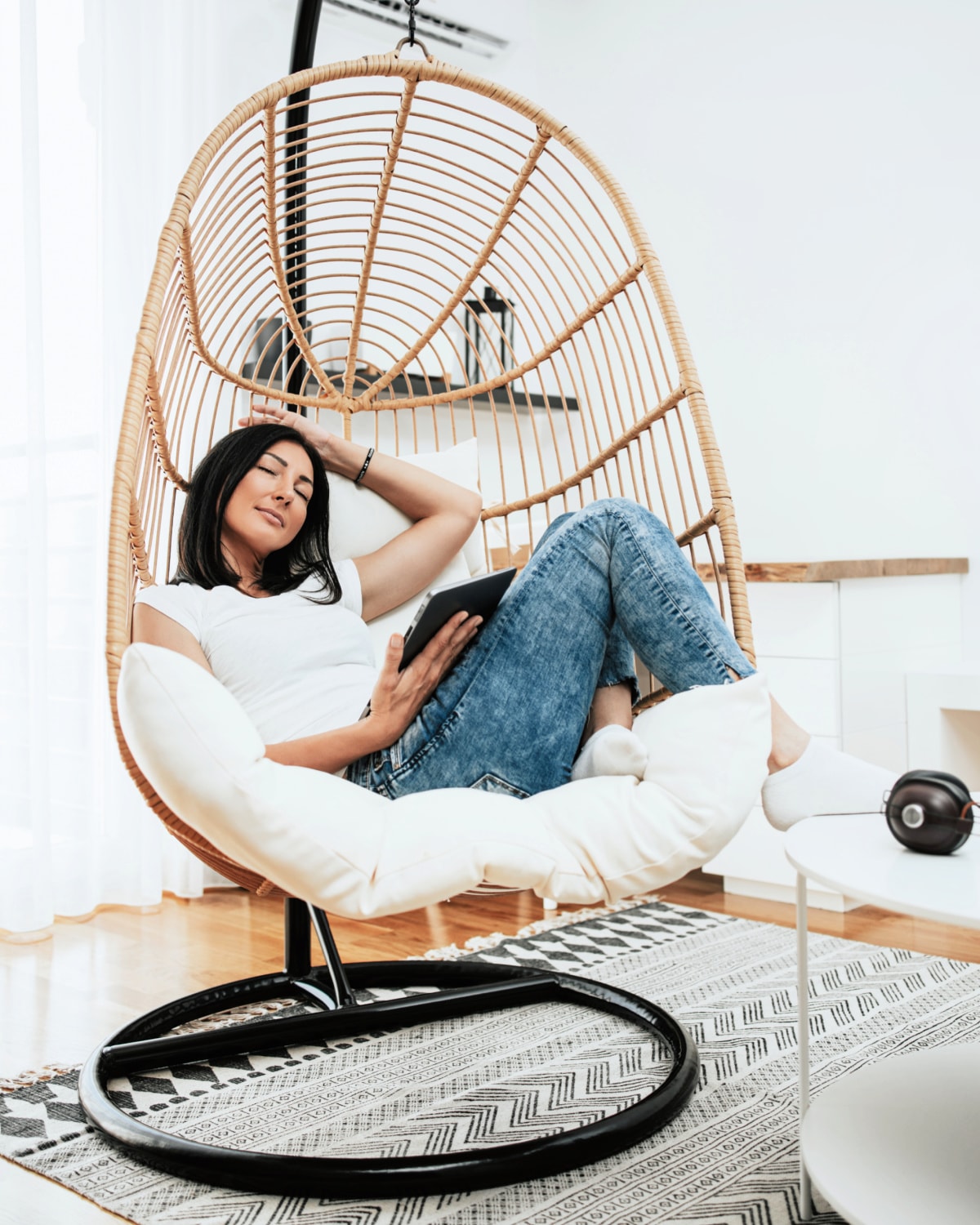 A woman reading tips on how to make life easier while relaxing in a beautiful chair