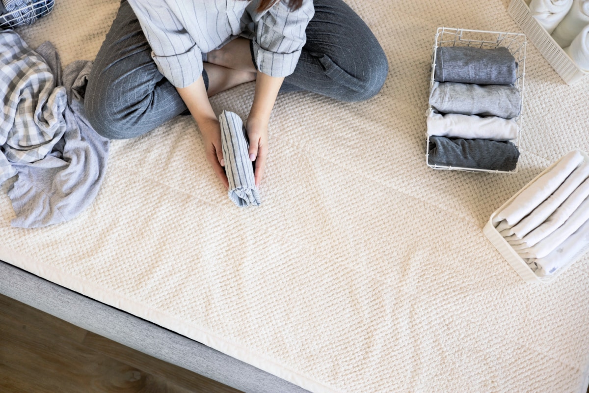 A woman using the Marie Kondo folding technique to tidy up her closet.