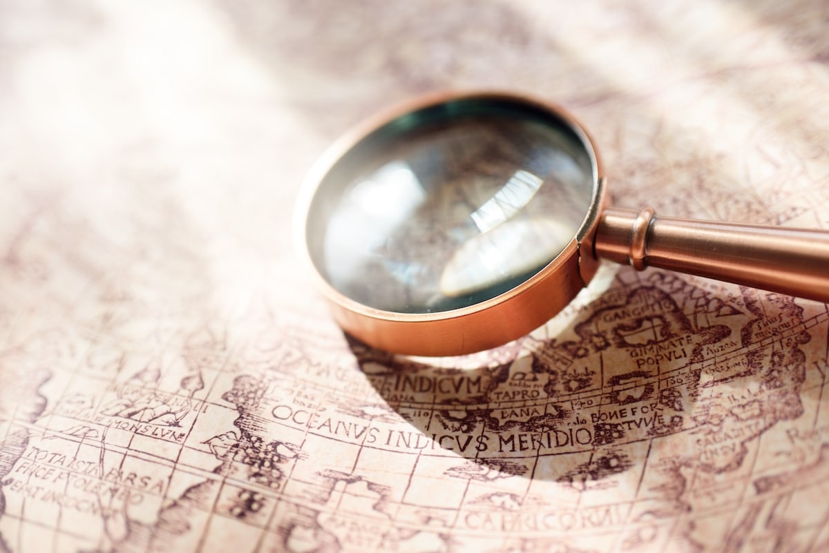 A rose gold magnifying glass on a map 