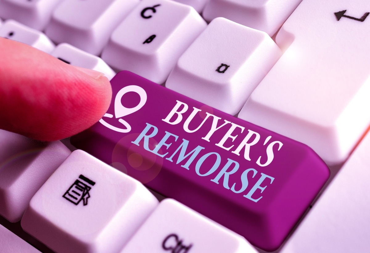 A finger getting ready to push a computer keyboard button labeled "buyer's remorse".