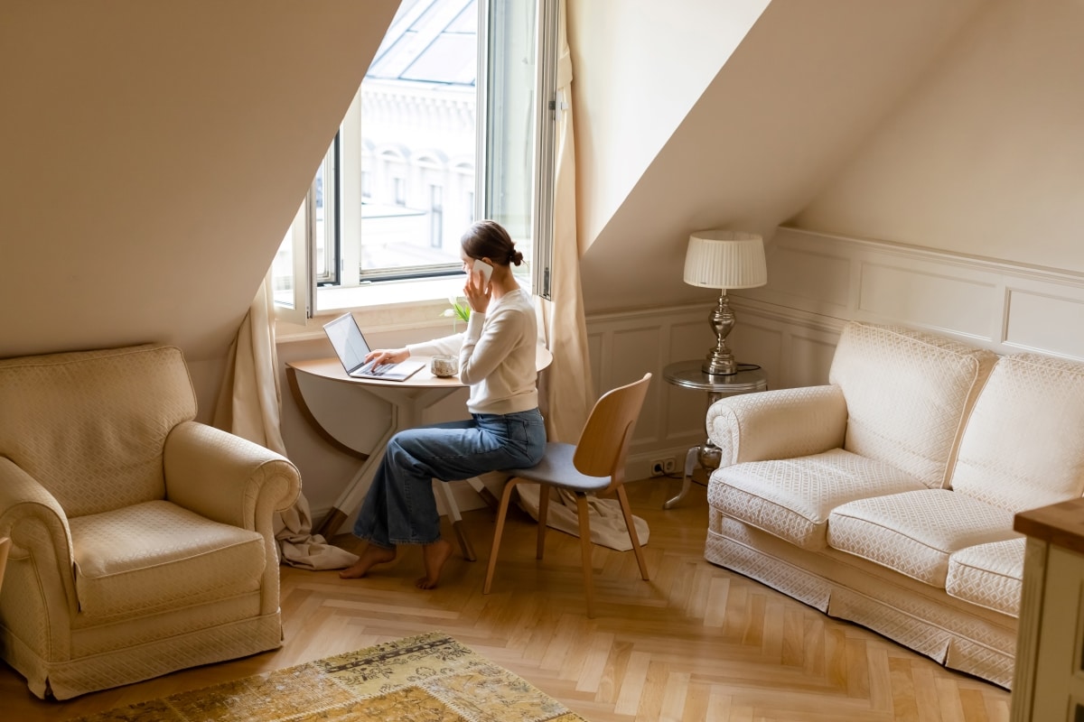 A frugal minimalist woman working from home in a calm and peaceful living room.