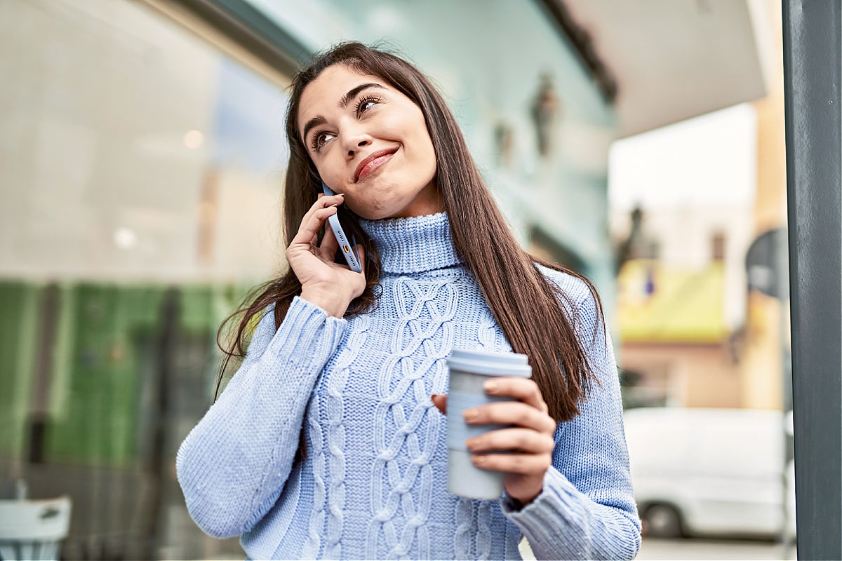 A woman smiling as she deal with her toxic mom on the phone