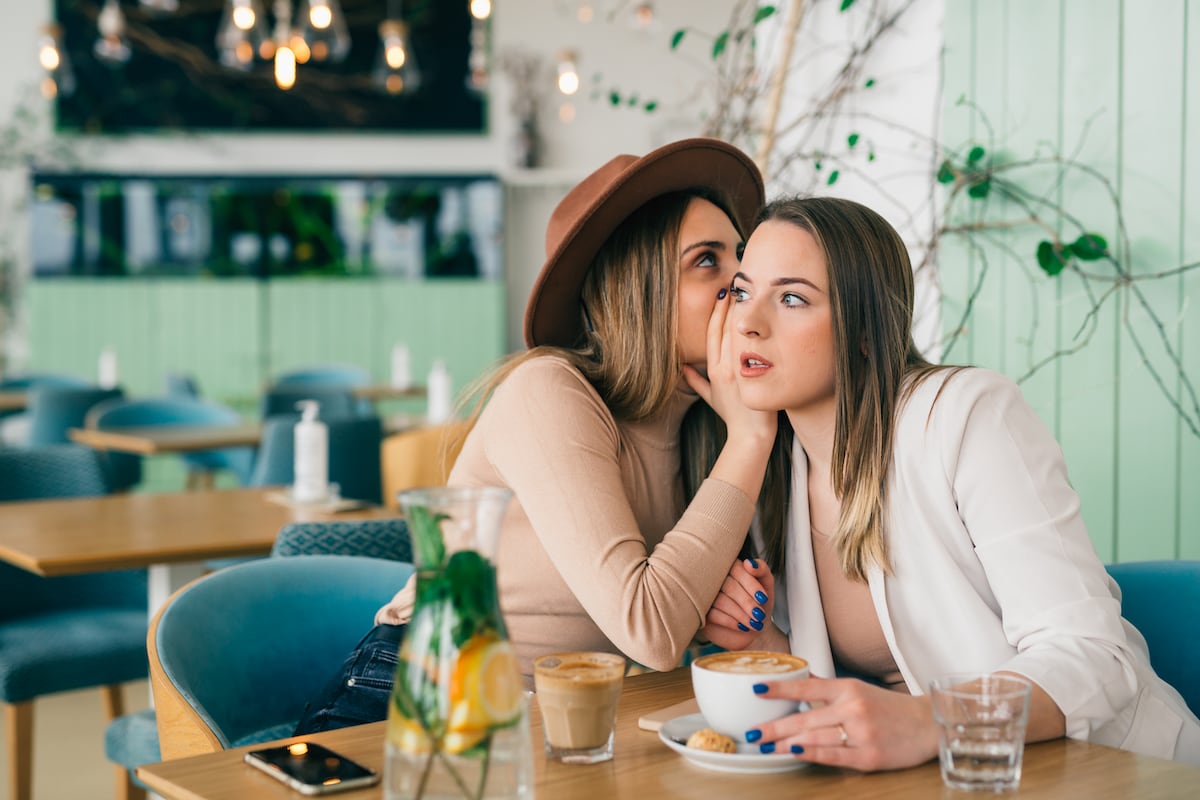 Toxic friends gossiping over a cup of coffee in a cafe