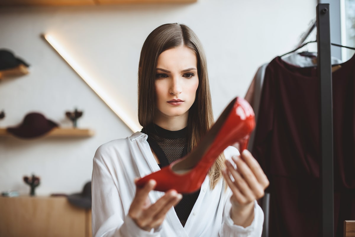 A materialistic person looking sadly at red shoes