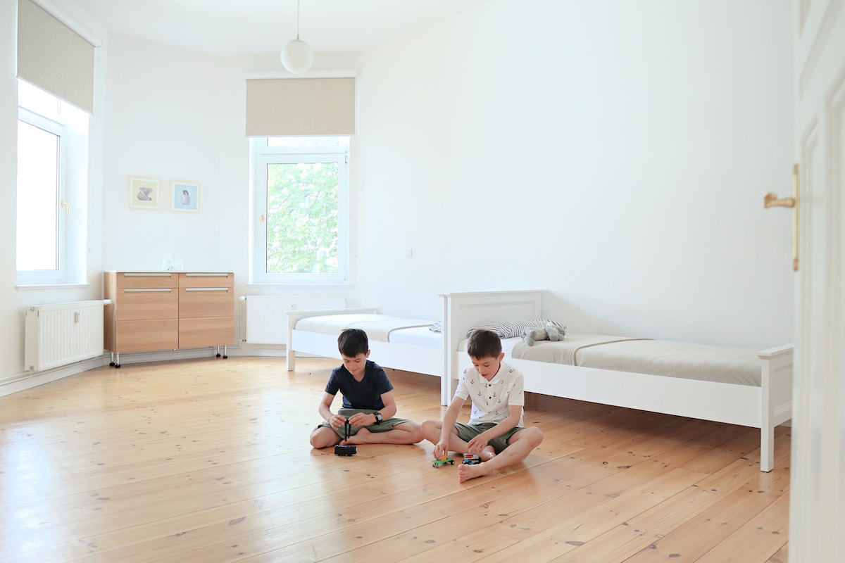 Two young boys playing in the bedroom of their minimalist family home