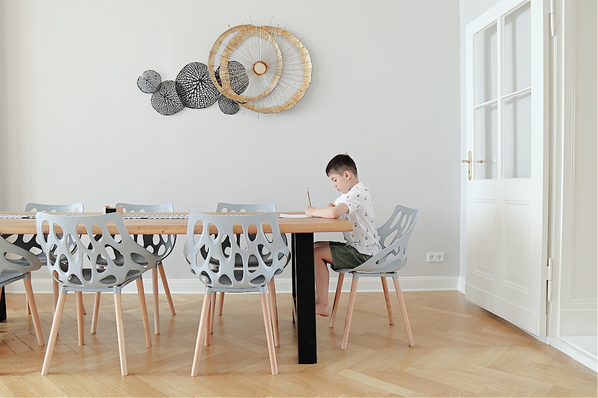 A boy doing homework at the table his minimalist family room