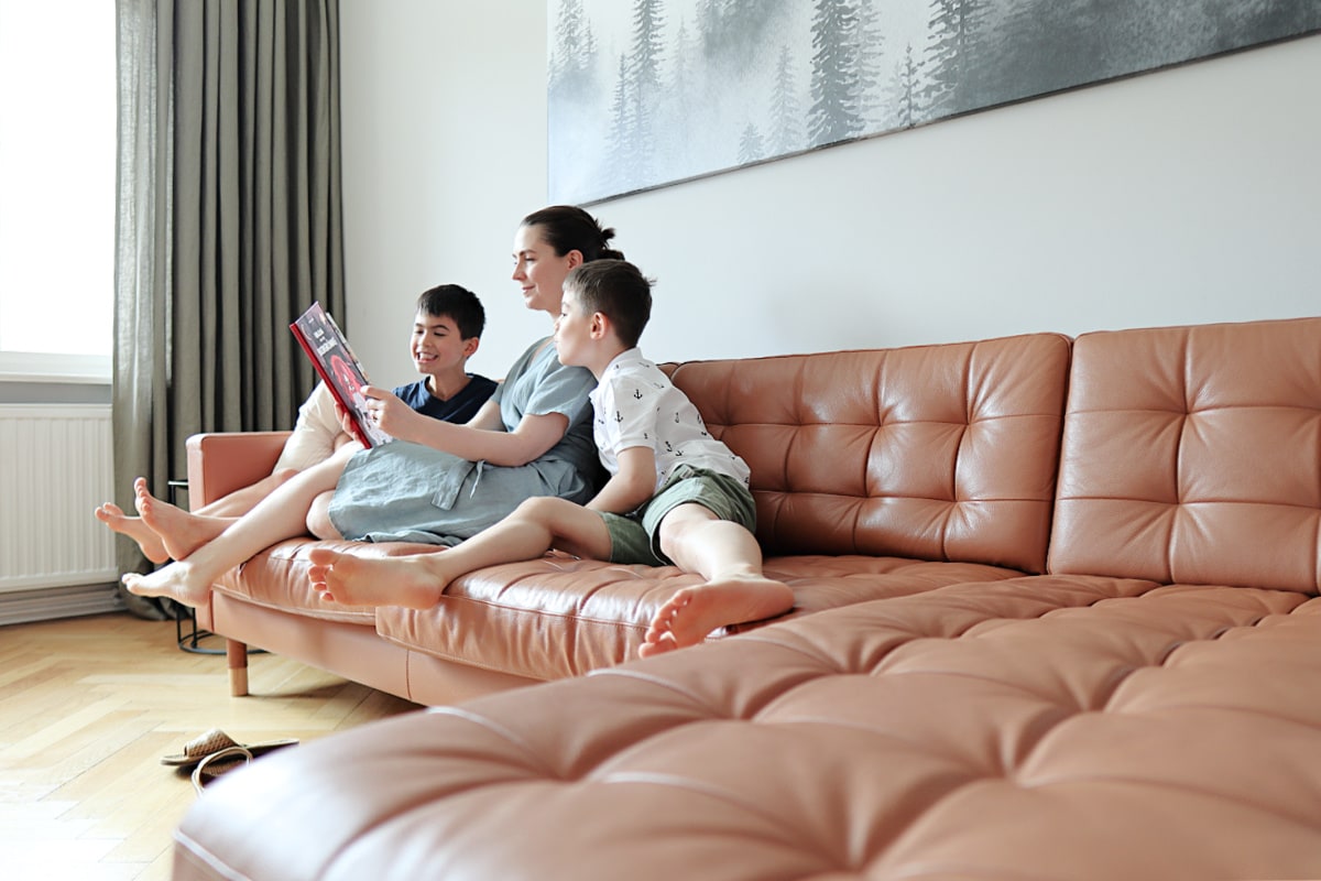 A minimalist mom reading to her children on the couch in her minimalist living room