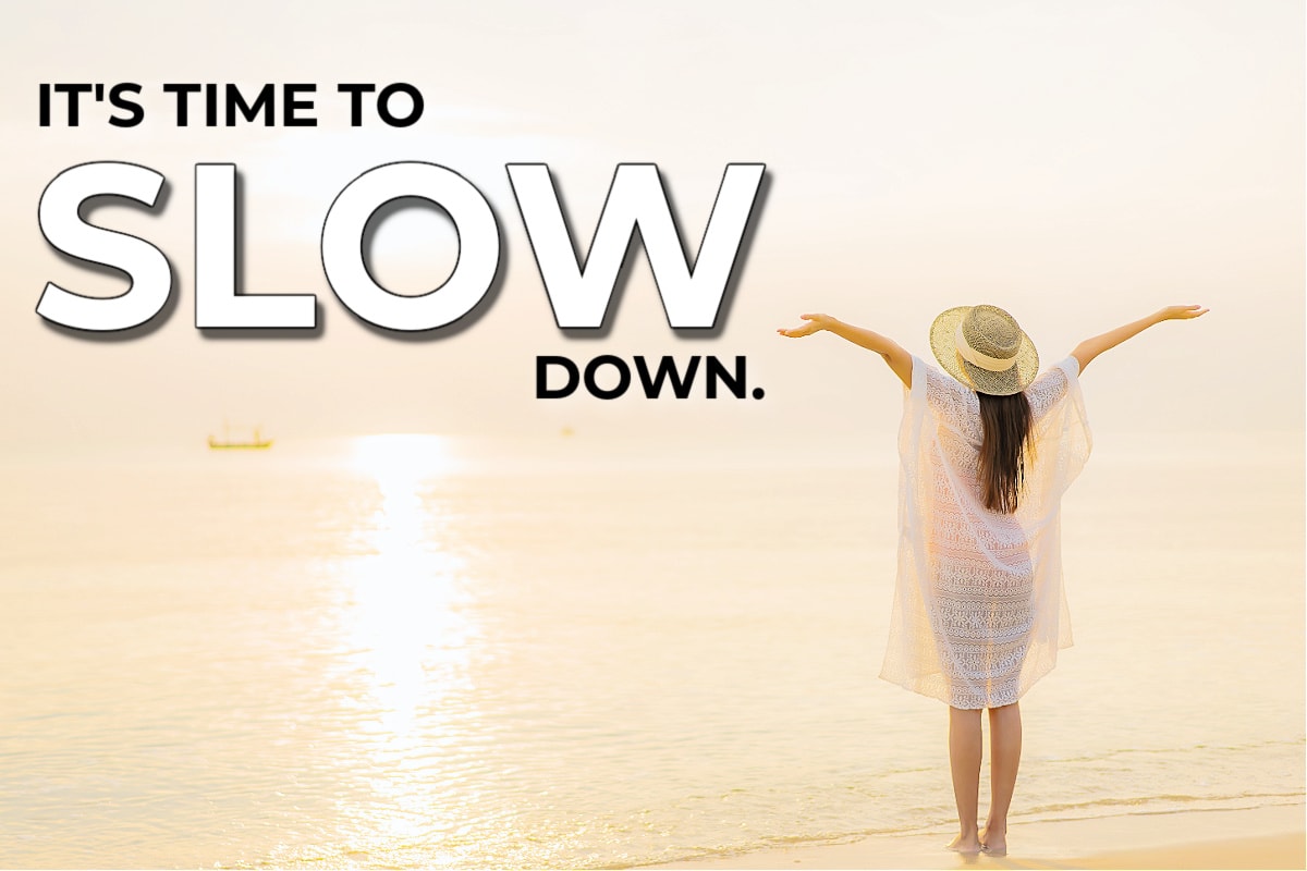 A woman joyfully raising her hands to the sky after reading inspiring slow down quotes.