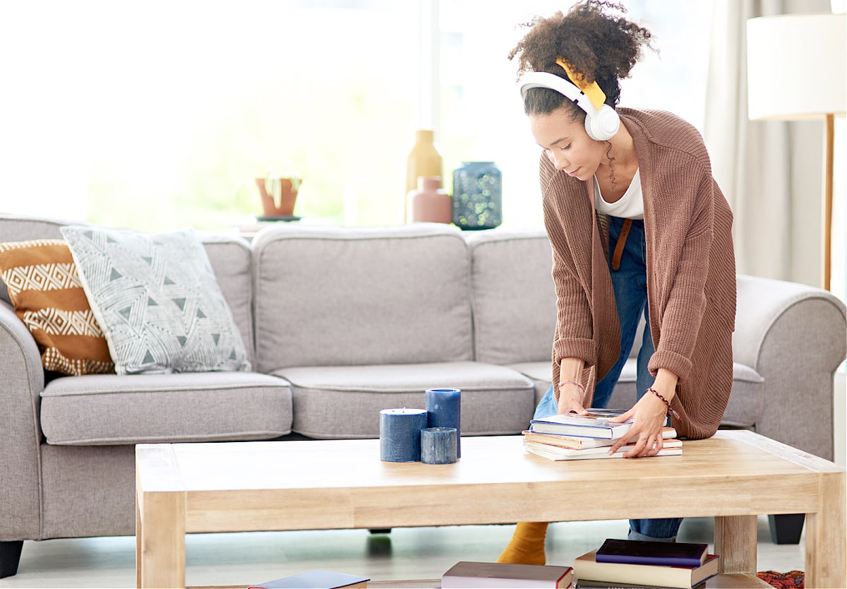 A woman listing to music as she follows a decluttering list of things to get rid of in her home