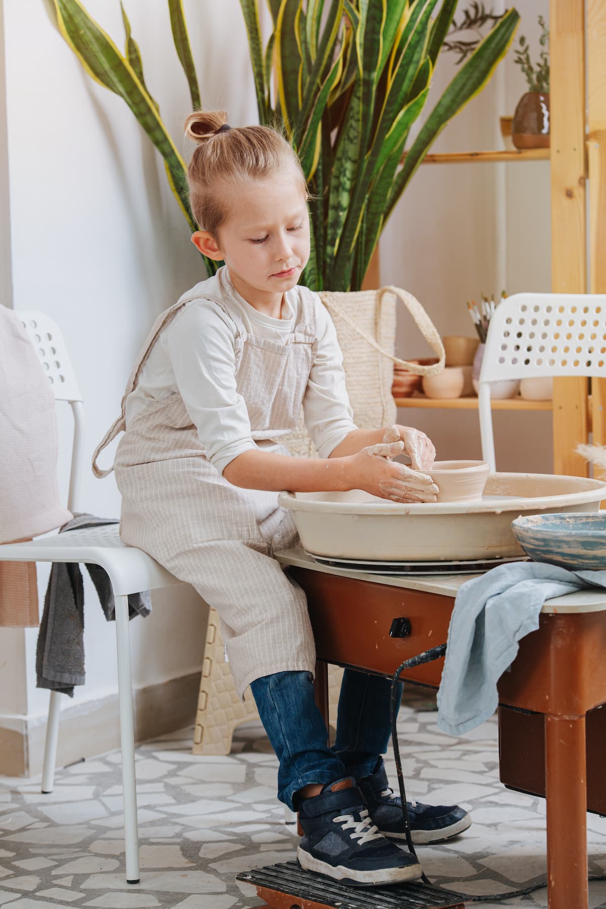 A child participating in a pottery class they got as an experience gift