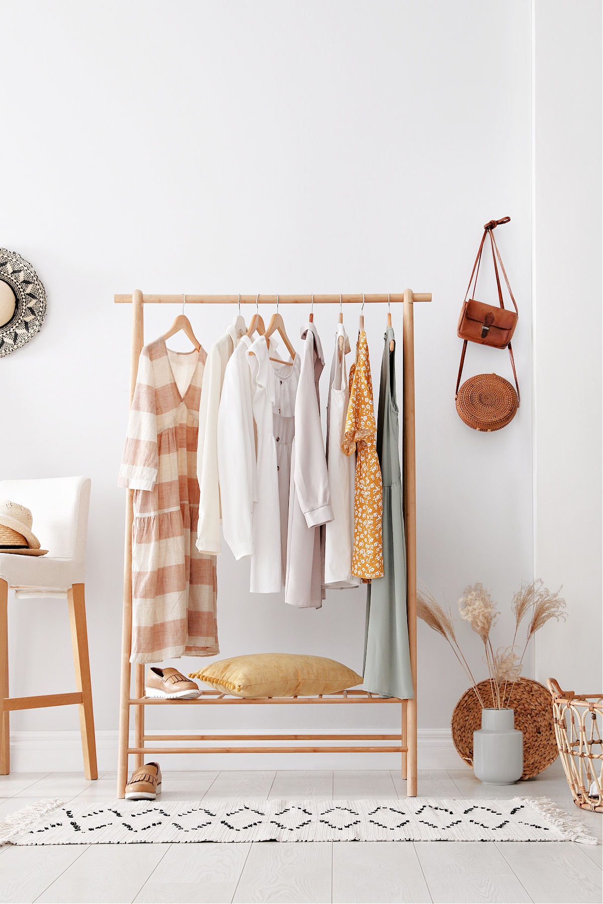 A beautiful minimal wardrobe for women in a pretty minimalist fashion designers bedroom.