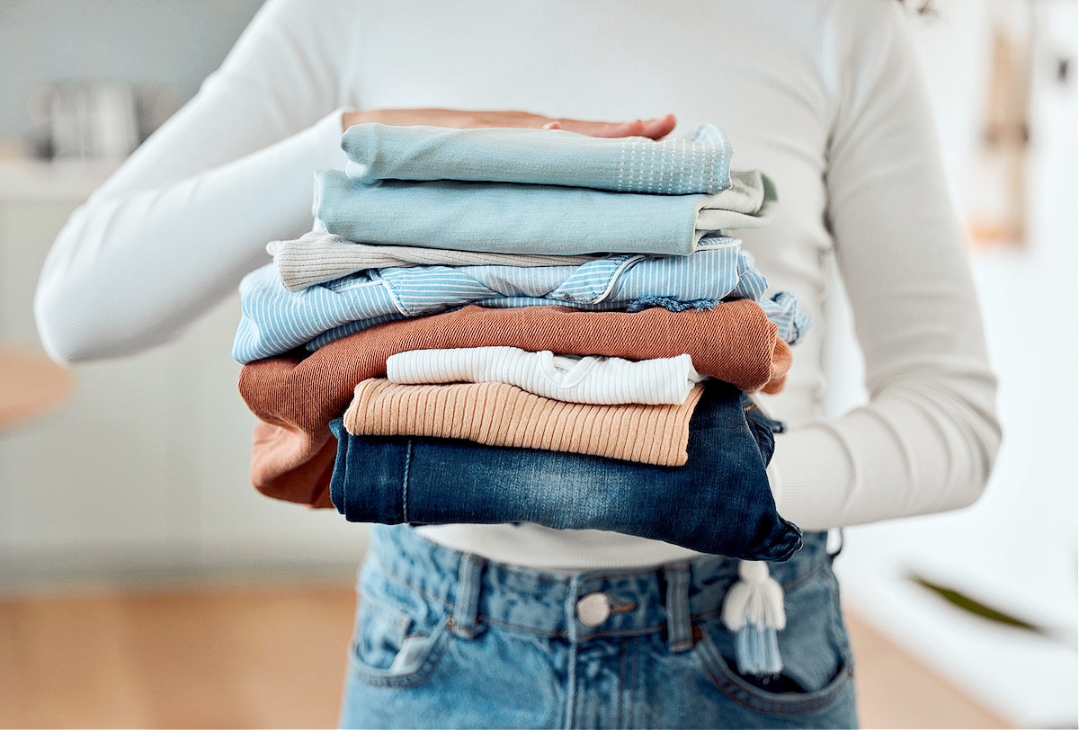 A woman following tips to declutter faster to purge her wardrobe and get rid of clutter