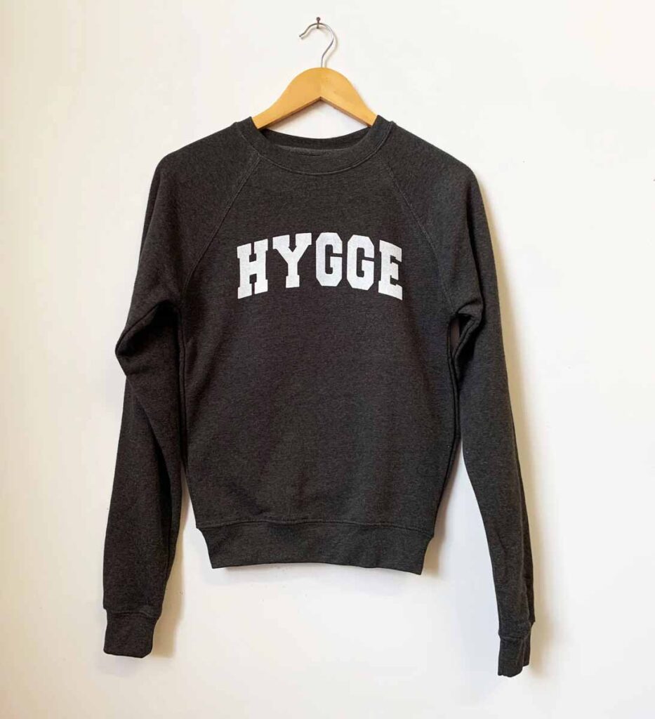 black sweatshirt with white lettering that reads Hygge