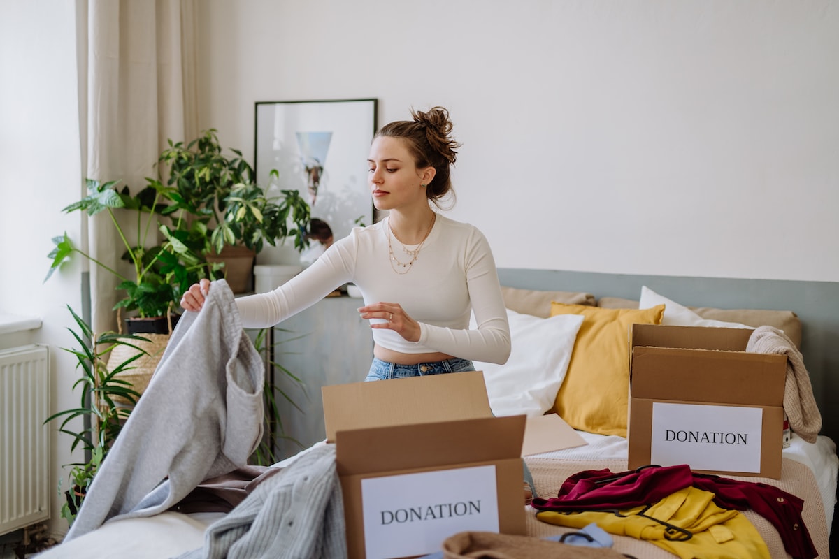 A woman using decluttering as an example of self-care to keep her home tidy and mind at peace.